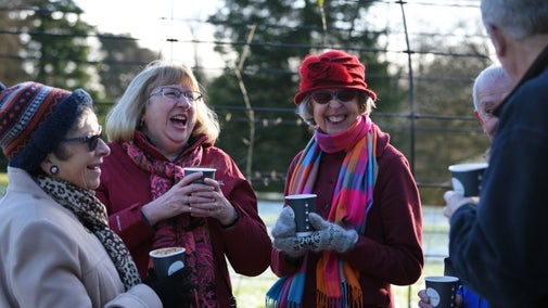 Visitors warming up with a hot drink at Quarry Bank Mill, Cheshire